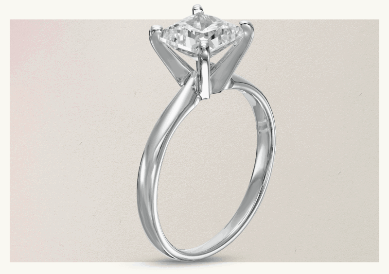 Facing upright silver ring band with four-prong square-cut diamond placed on center.
