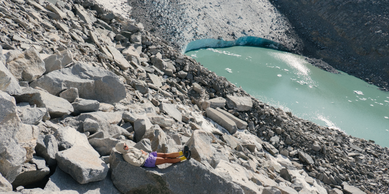 Emi sitting on rocks overlooking water.