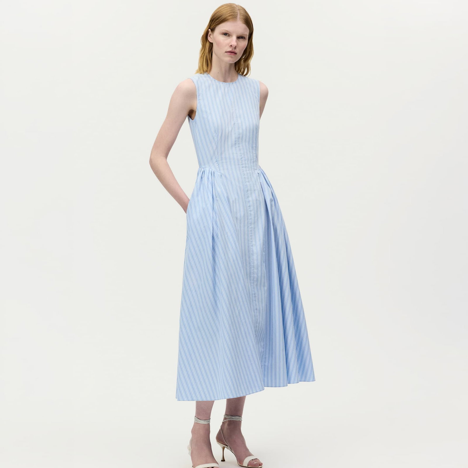Image of a model wearing the aliena dress in pale blue and white stripes.