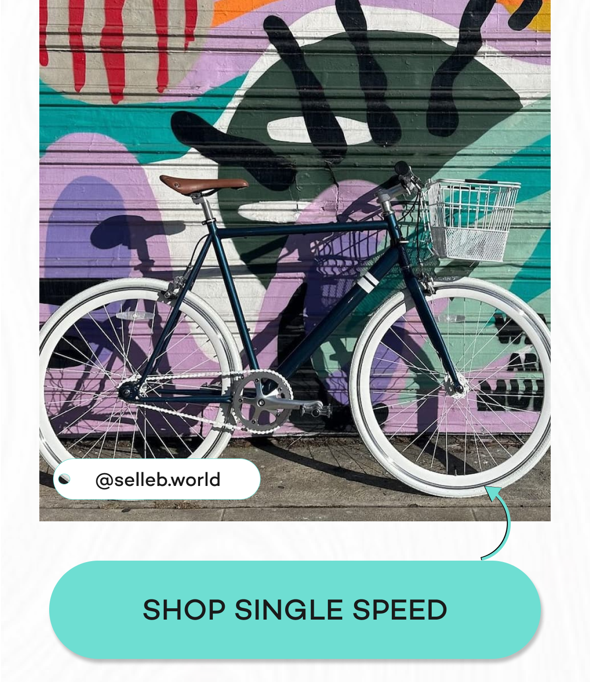 A stylish bicycle with a basket parked in front of a colorful mural.