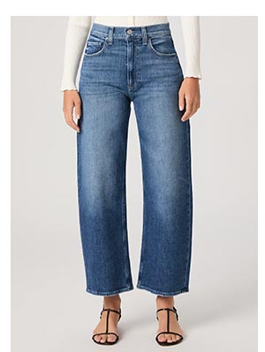 Image of a woman's legs in barrel cut vintage wash medium blue denim jeans.