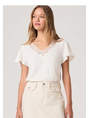 A woman wearing a white short sleeve t-shirt with lace collar and capped sleeves.