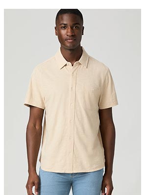 An image of a man wearing a light peach short sleeve button up top.