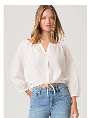 A woman wearing a white long sleeve button front blouse.
