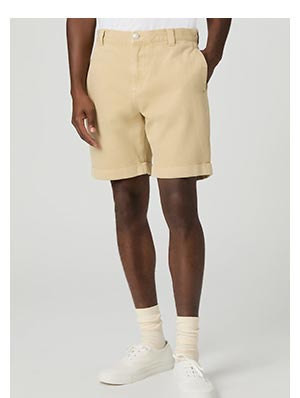A man wearing a pair of buttery tan denim shorts with tonal stripe detail.