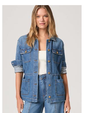 A woman wearing a medium blue wash denim jacket.