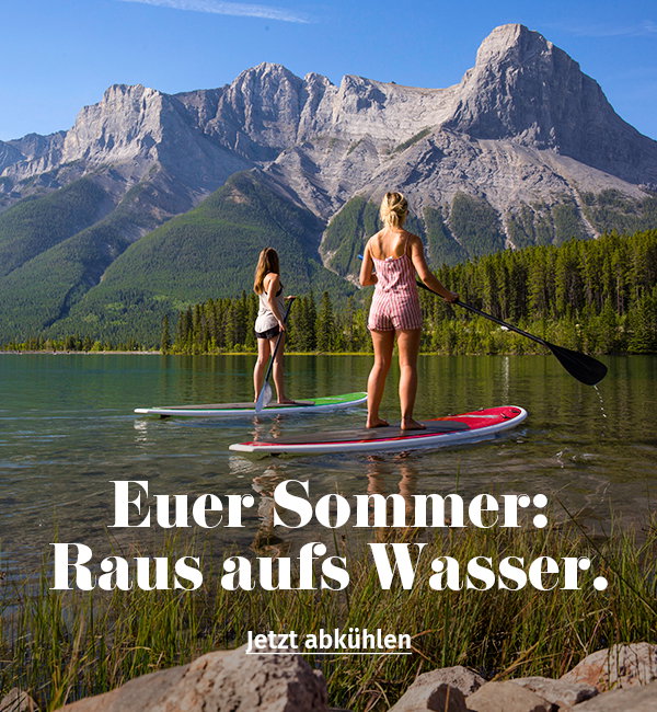 Zwei Frauen stehen auf einem Stand Up vor einer Bergkulisse.