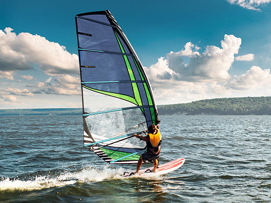 Ein Windsurfer bewegt sich auf dem Wasser.