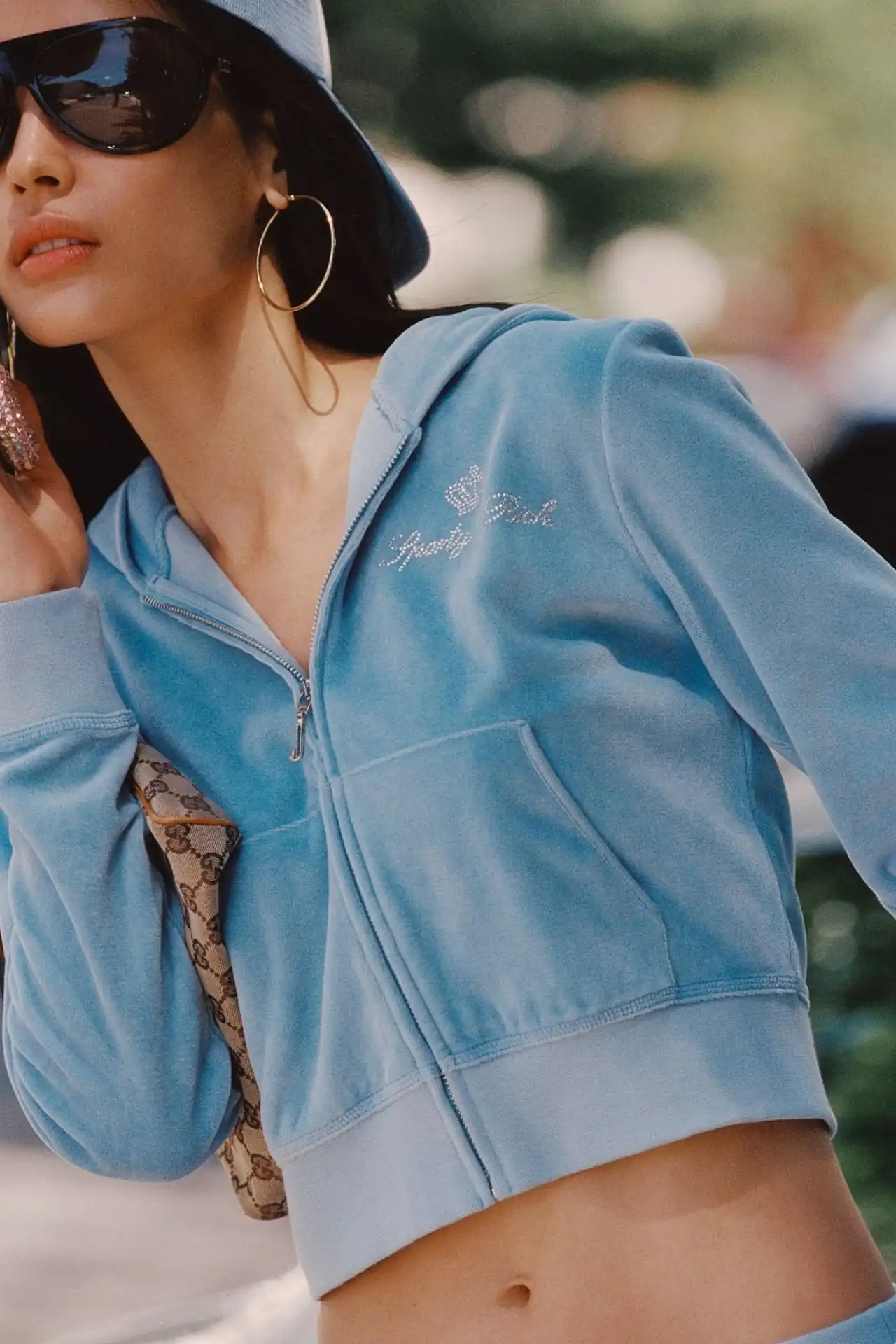 A medium shot shows a person wearing a light blue velour zip-up hoodie with the text 'Pretty Rich' and a crown emblem embellished with rhinestones on ...