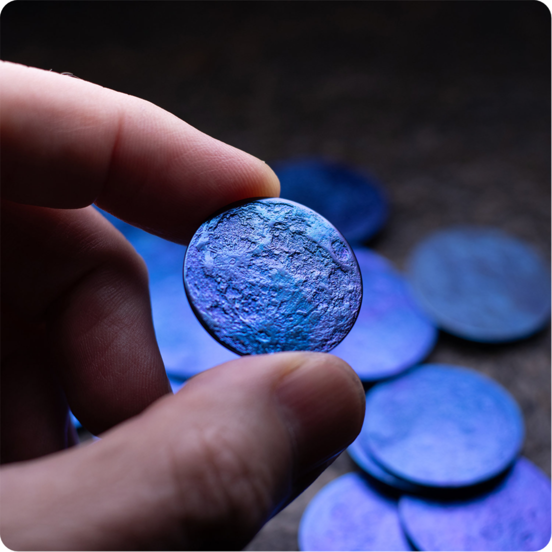 Hand holding niobium blue moon coin