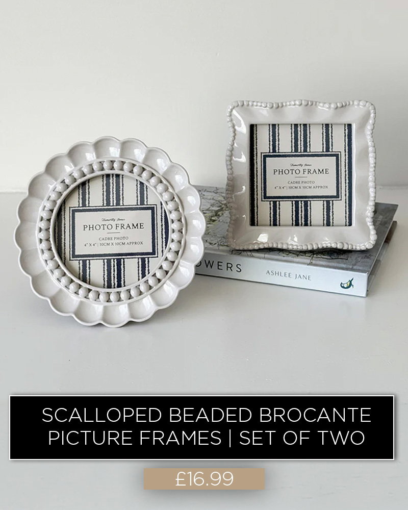 White scalloped beaded photo frames displayed on books