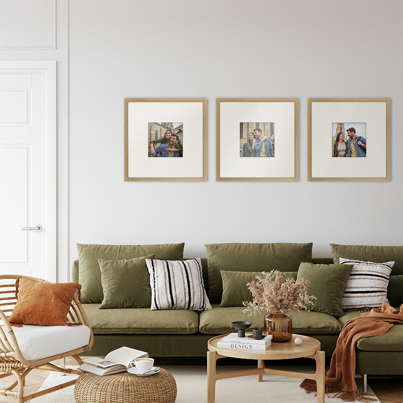 Minimalist living room with neutral tones, green sofa, and framed wall art.