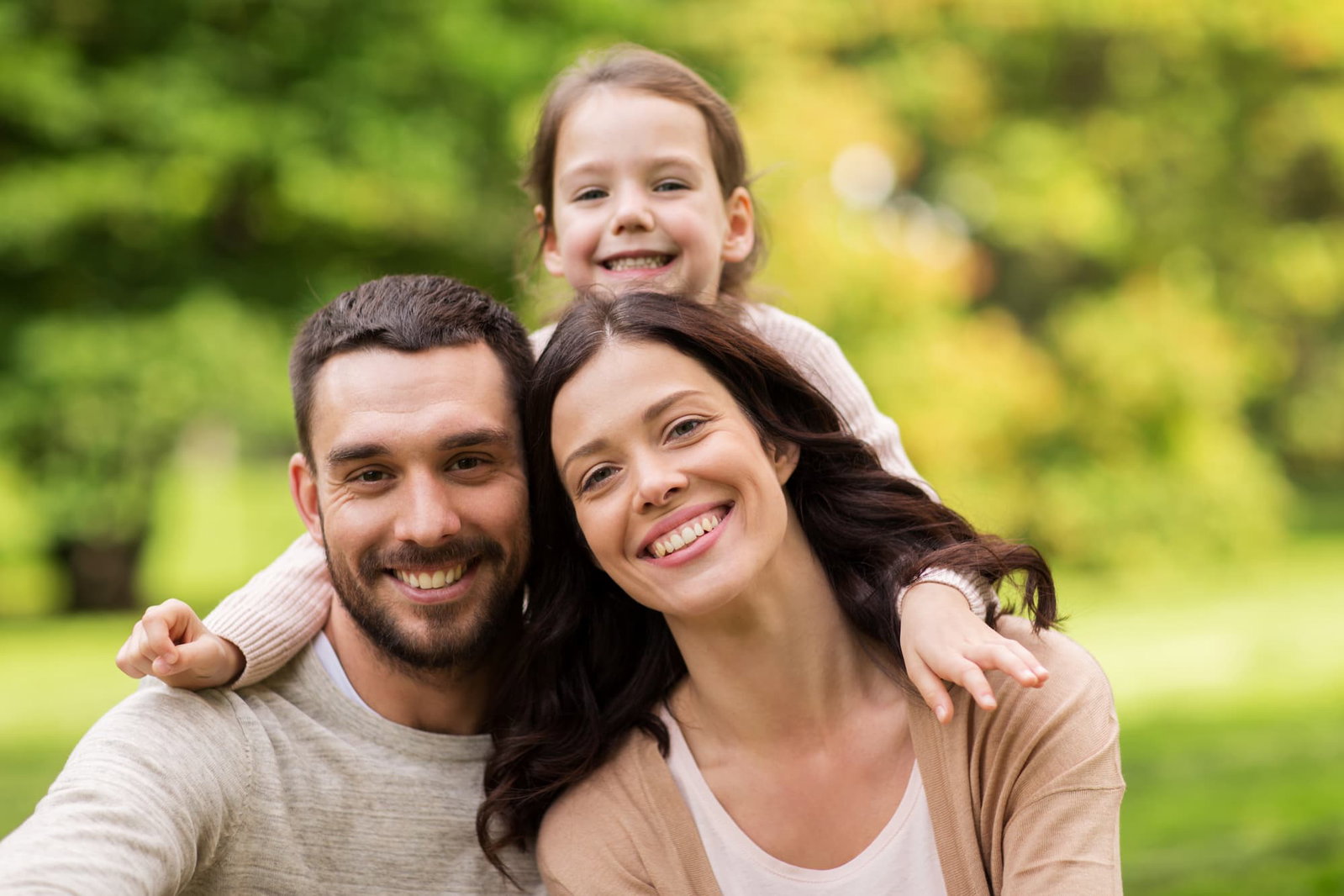 Man, woman, and child smiling outside