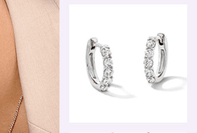 A pair of white metal diamond hoop earrings.