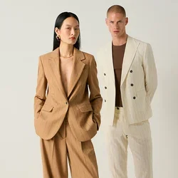 Twee modellen staan tegen een effen achtergrond, één in een beige pantalonpak met krijtstrepen, de ander in een crèmekleurig krijtgestreept pak met een bruin overhemd en zwarte schoenen.