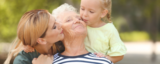 C'est une maman qui embrasse sa fille ainsi que sa petite-fille.