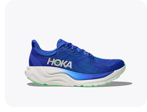 A block of three images: one image shows a man looking to the side, sitting with his elbows resting on his knees, with his shoe in the foreground; one image shows a side view of the Arahi 8 in cobalt blue / neon green; one image shows a side view of the ORA Recovery Slide 3 in neon flame / neon flame.