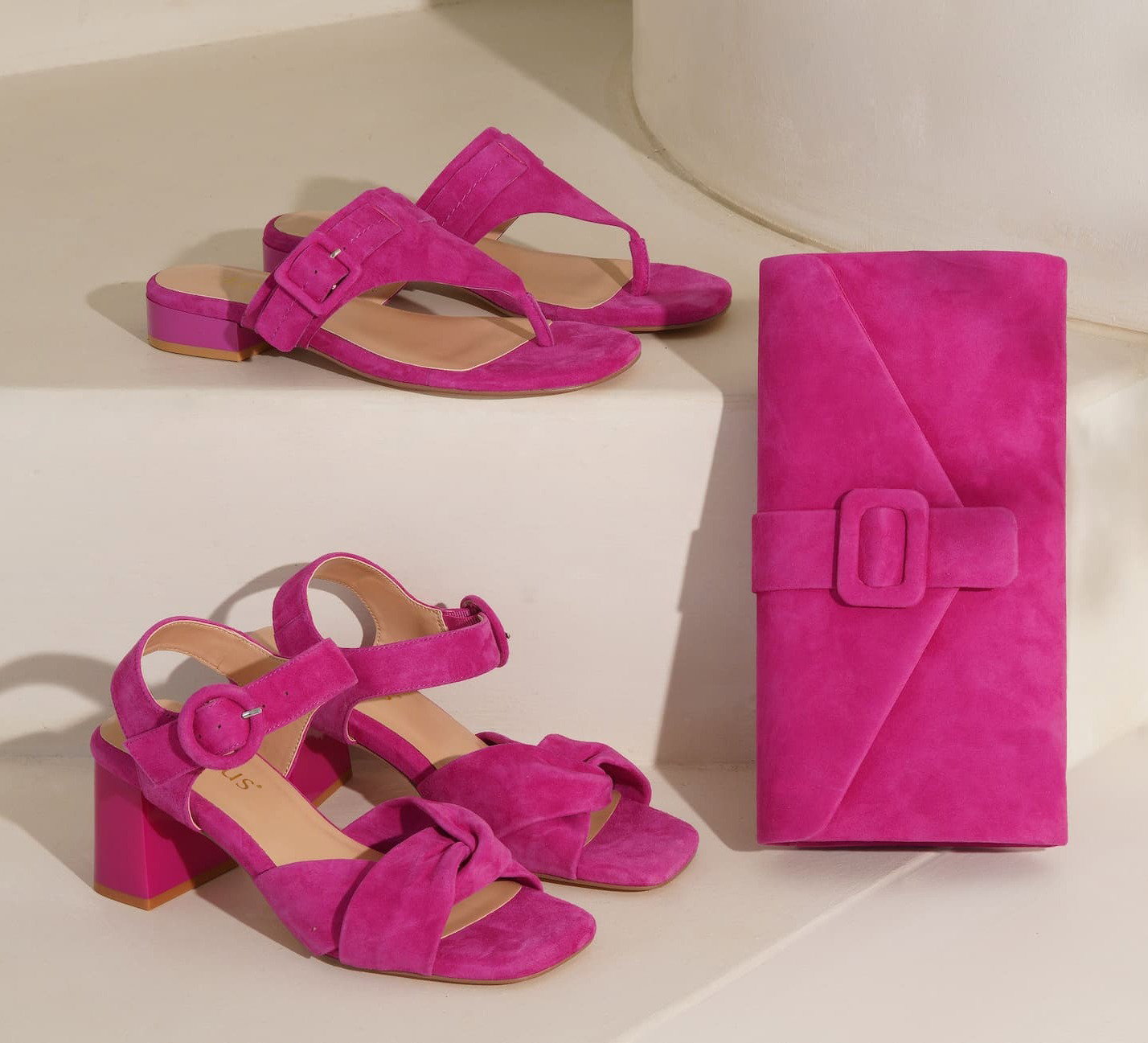 An image of two pairs of Lotus fuchsia pink sandals and a fuchsia pink handbag