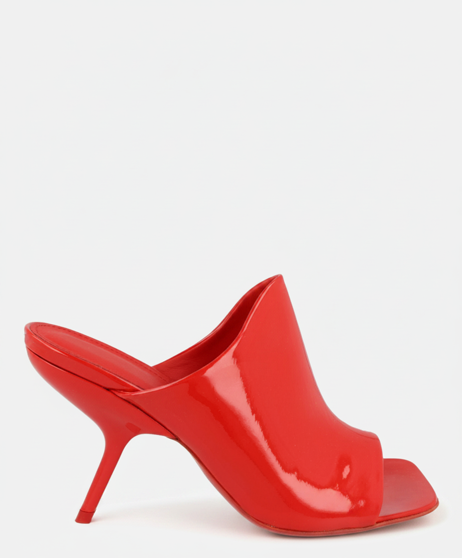 A red patent leather mule with a square toe and a thin, curved heel.