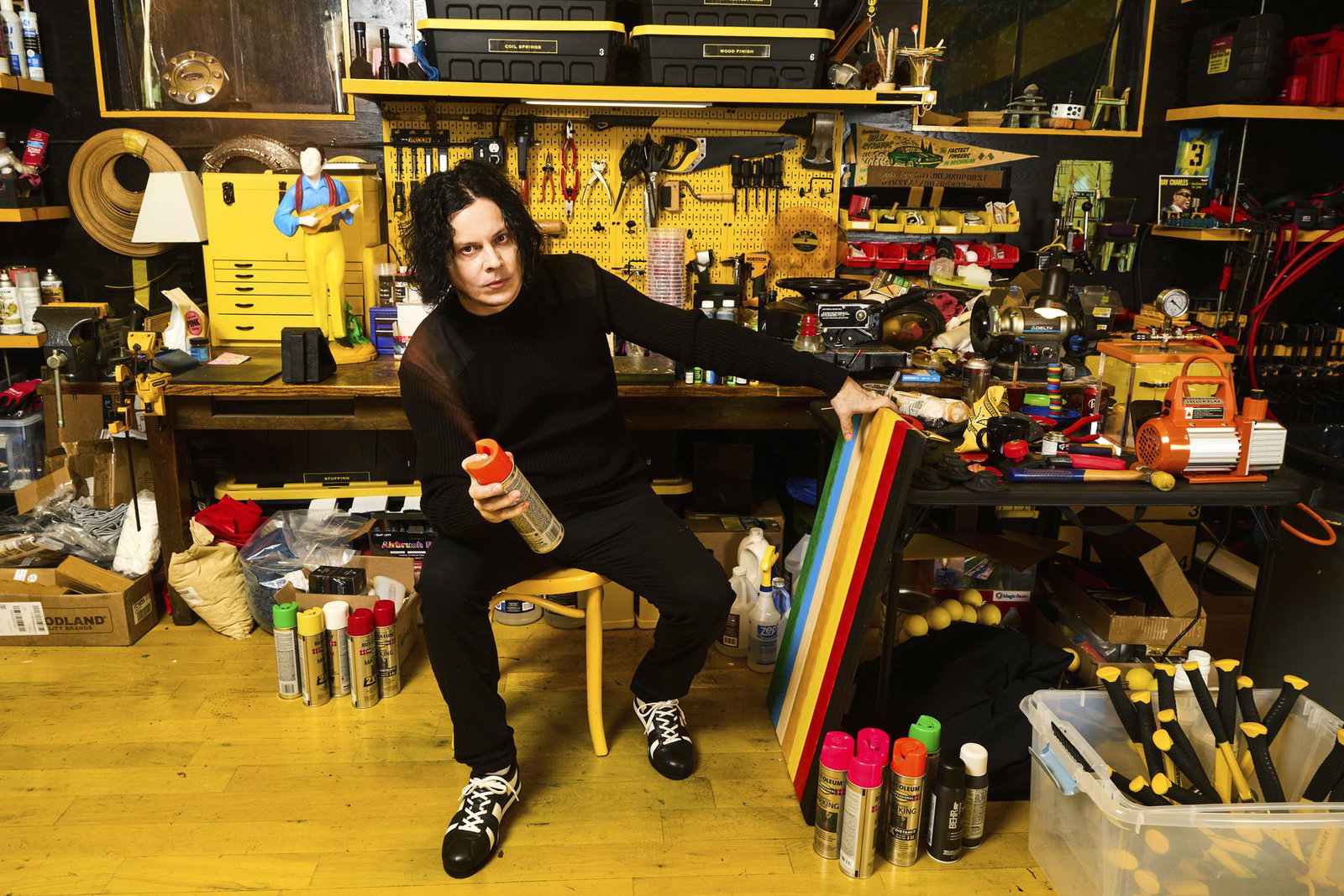 Jack White in his studio with a spray can and a striped artwork in progress