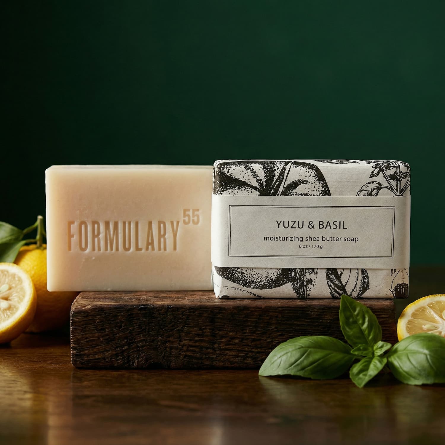 Yuzu & Basil Bar of Soap next to fresh basil and yuzu against a dark green background
