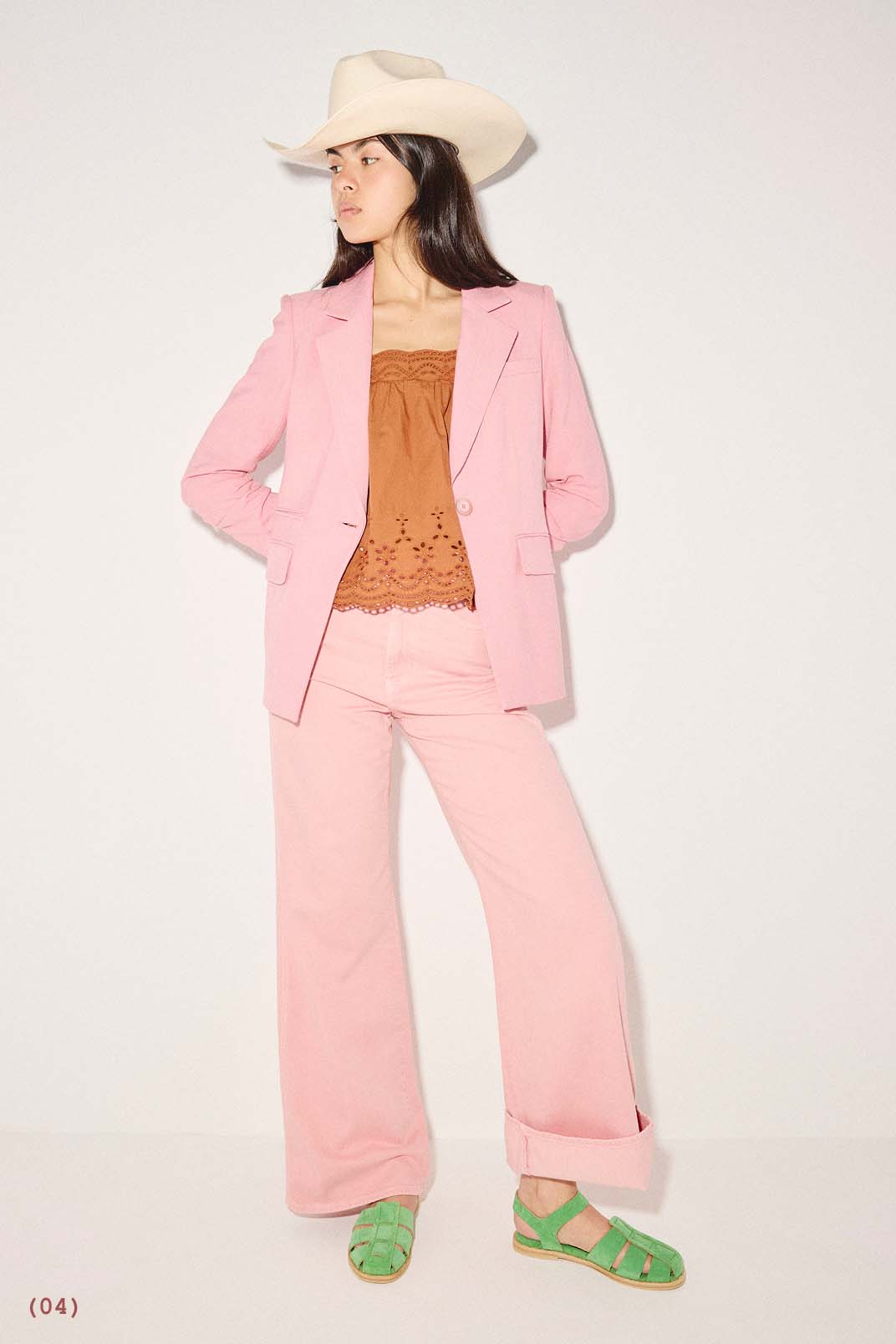 SERA in Kelly Green Suede styled with a pink blazer, brown tube top, and matching pink trousers.