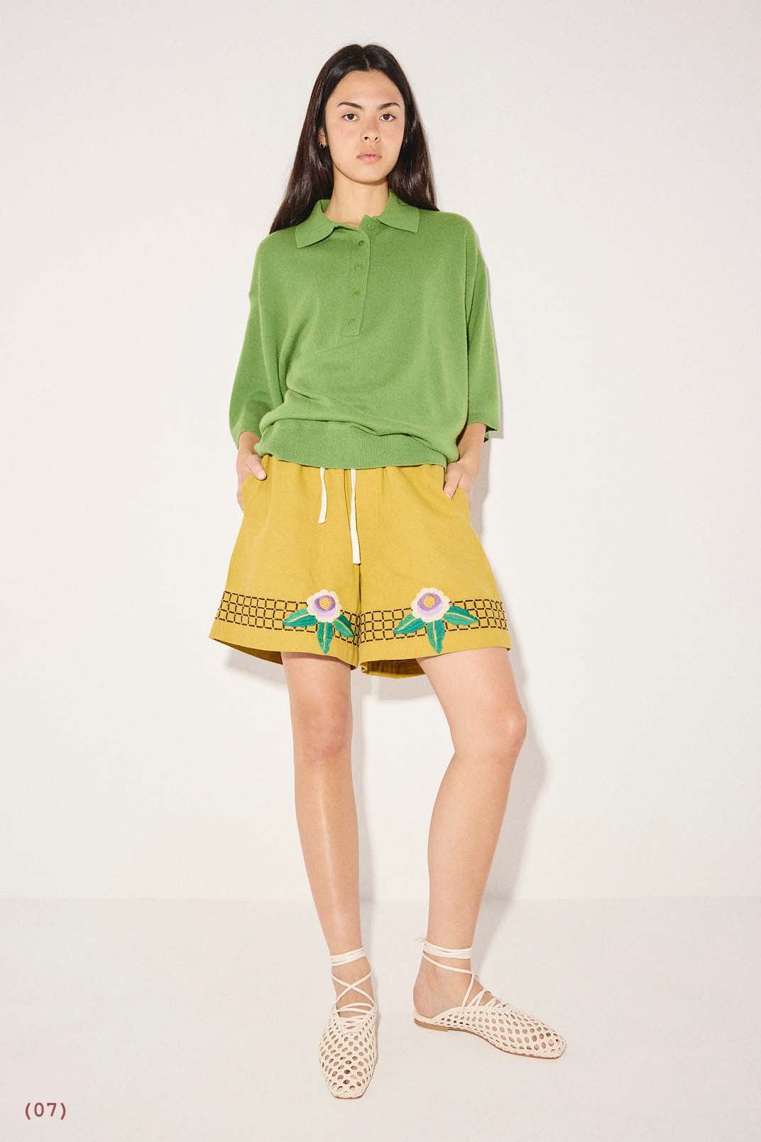 ETTA woven flat in vanilla calf styled with a green short-sleeve polo shirt and yellow embroidered shorts.