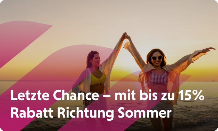 Zwei Frauen tanzen im Licht der untergehenden Sonne am Strand. Jetzt Flüge buchen und bis zu 15 % sparen.