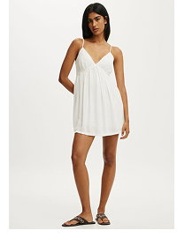 Woman wearing a white sleeveless mini dress with sandals