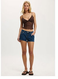 Woman wearing brown camisole and denim shorts