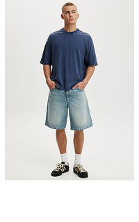 Man wearing navy t-shirt and light blue denim shorts