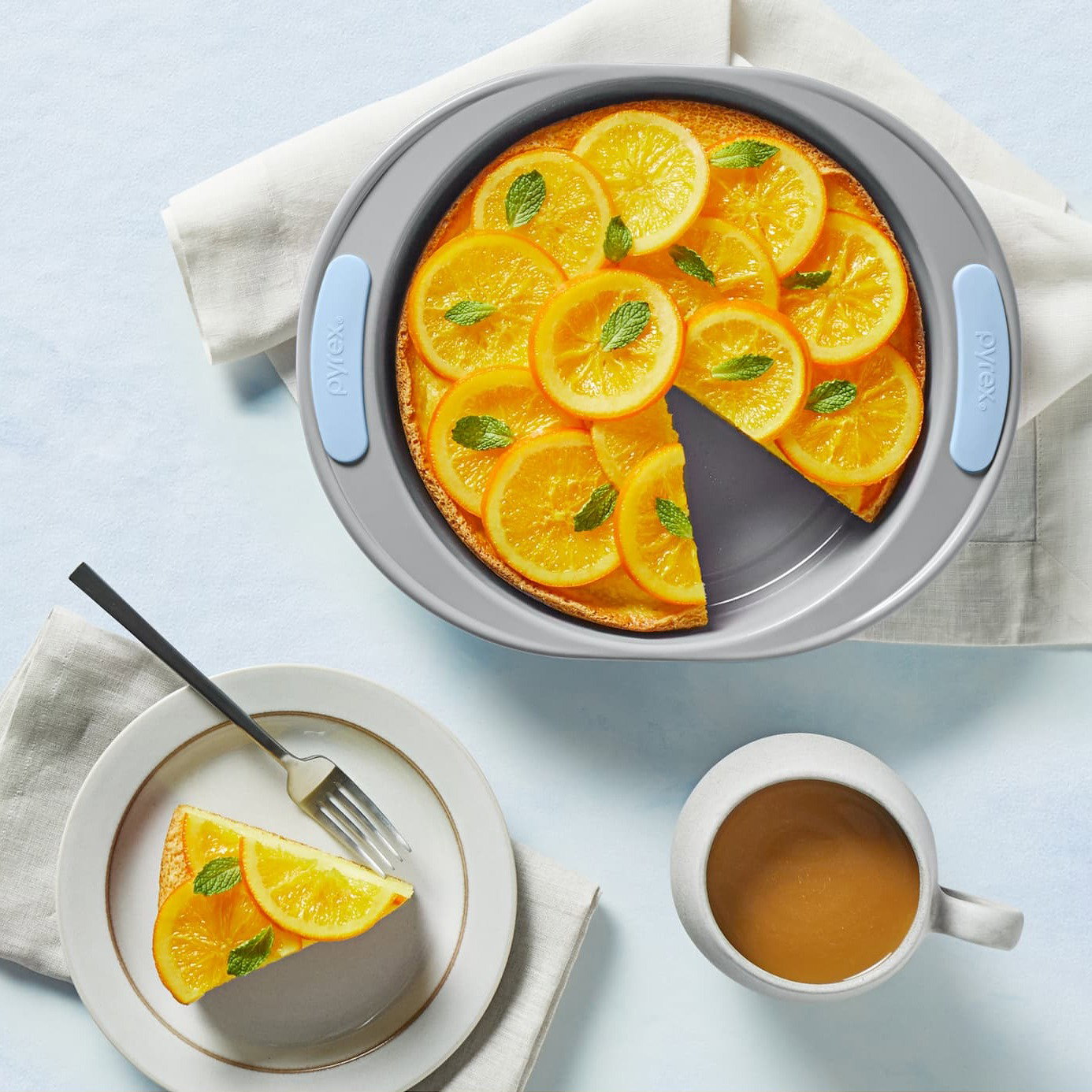 Baked citrus orange tart in a Pyrex dish with sliced oranges on top.