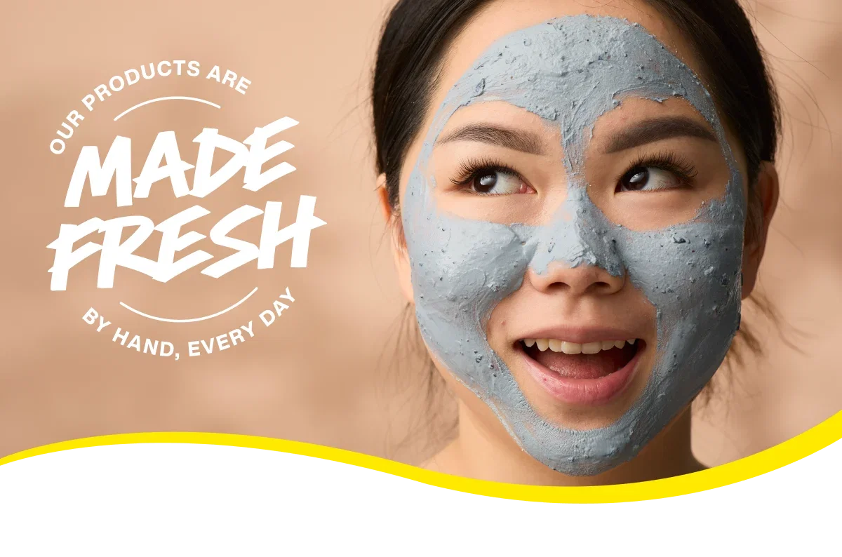 Person with fresh face mask on with sticker: OUR PRODUCTS ARE MADE FRESH BY HAND, EVERY DAY