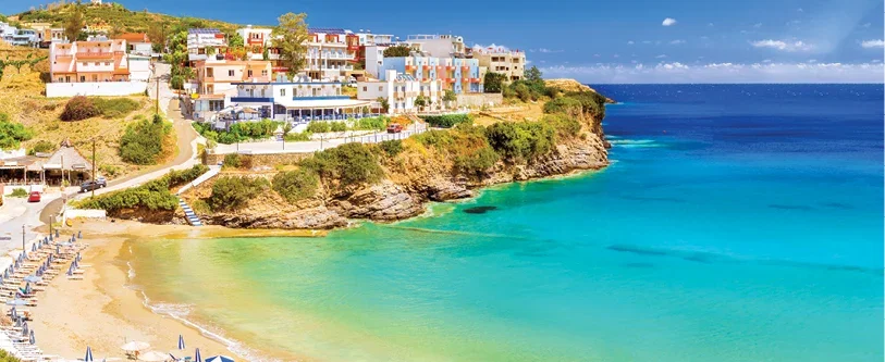 A colourful cliffside town overlooking a bright turquoise sea.
