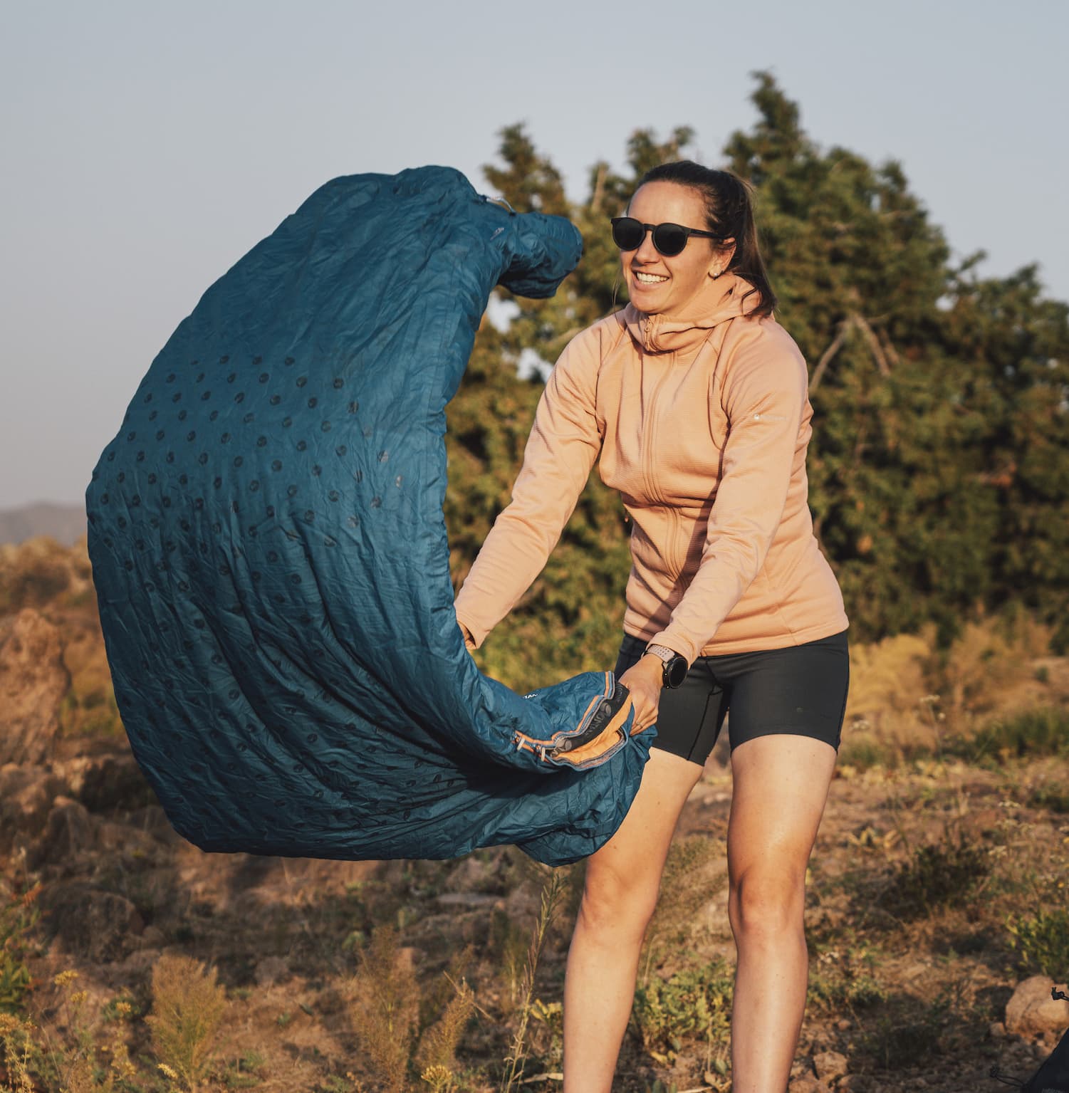 Jenny Tough unrolling her sleeping bag in the Fann Mountains