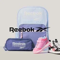 Mochila Reebok azul claro y púrpura, estuche para lápices púrpura y dos zapatillas para niños pequeños: una rosa y otra en blanco y negro, sobre un fondo gris.