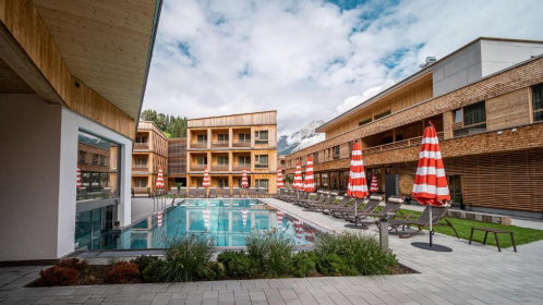 hotel mit außenpool liegen und sonnenschirmen
