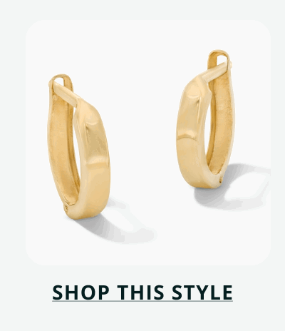 A pair of small, wide polished gold huggie hoops. Click here to shop this style