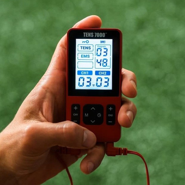A hand holding the TENS 7000 Sport Recovery TENS Unit