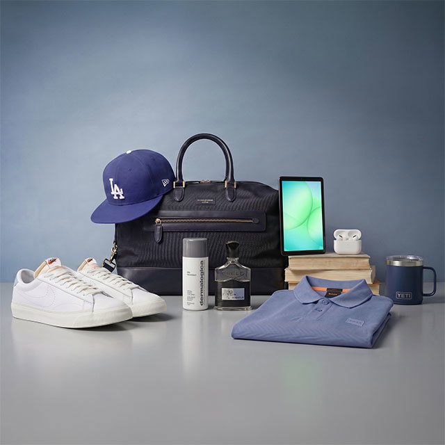 Collection of items including a blue cap, white sneakers, blue bag, shirt, tablet, AirPods, mug, cologne, and skincare products on a surface.