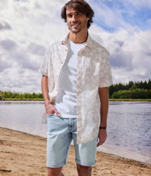Mann trägt Beachtime Freizeithemd mit Palmenprint in beige-bedruckt 