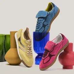 Quatre baskets colorées en vert, jaune, bleu et rose disposées sur et autour de vases aux formes uniques en vert, marron, bleu et rouge.