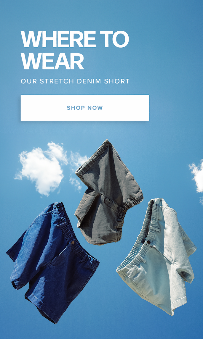 Three pairs of denim shorts in dark blue, grey, and light blue float mid-air against a bright blue sky with sparse clouds. Text reads: "Where to Wear Our Stretch Denim Short. Shop Now."