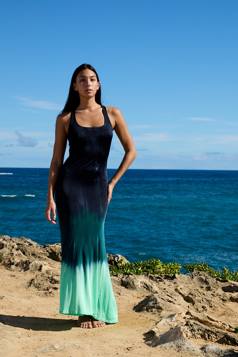 Woman wearing teal ombre dress standing on a beach