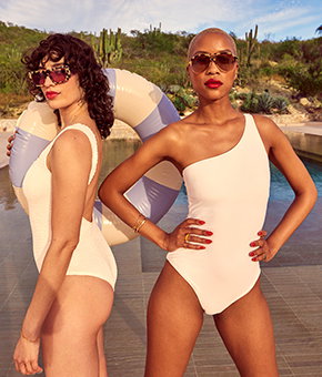 Two models wearing striking white swimsuits. 