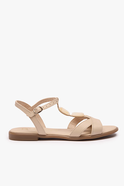 Beige leather sandal with ankle strap and flat sole on white background.