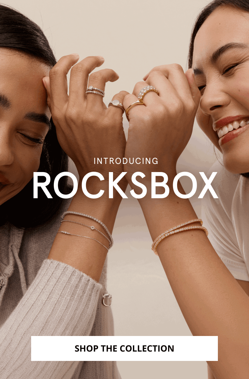 Two women wearing stacked rings and layered diamond bracelets. Introducing Rocksbox. Click shop the collection.