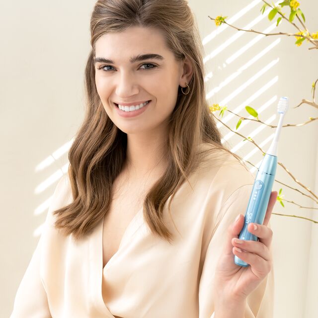 Woman using the Sonic toothbrush