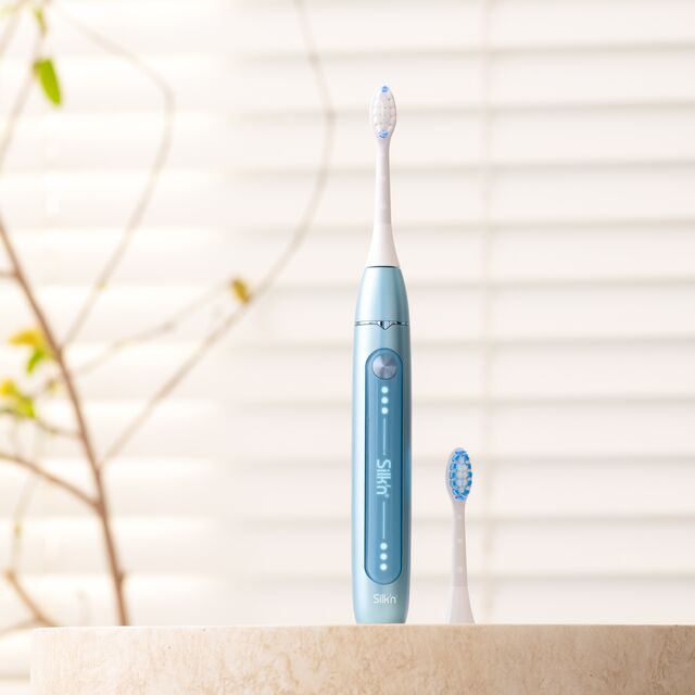 Woman using the Sonic toothbrush