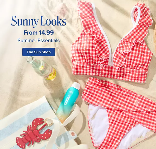 Sunny looks from 14.99 summer essentials. Shop the sun shop. A red and white checkered bathing suit next to a woven sun hat, tote bag and sun care products on the beach.